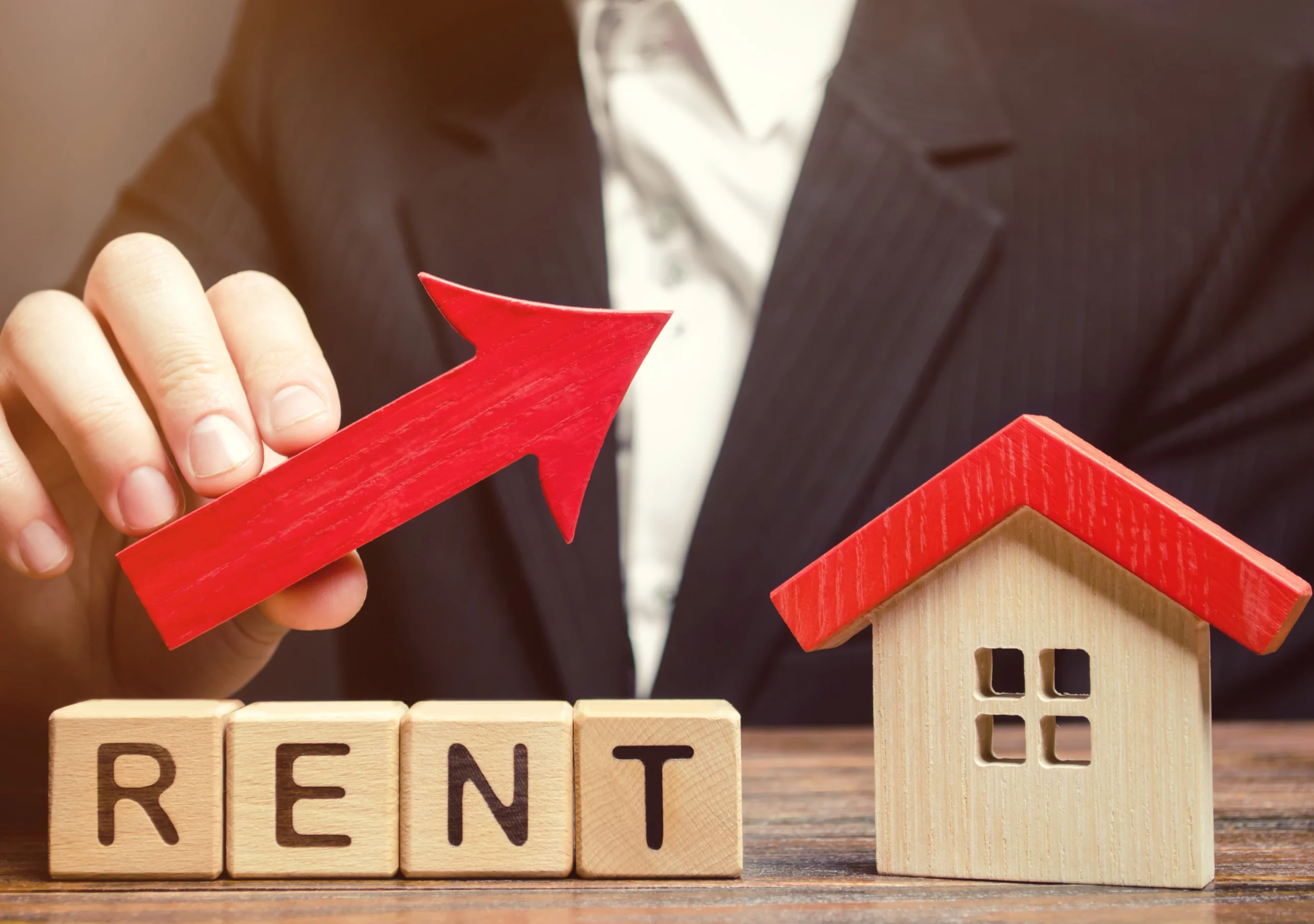 Red arrow rising beside rent blocks and house model, symbolizing rental increase under Florida law