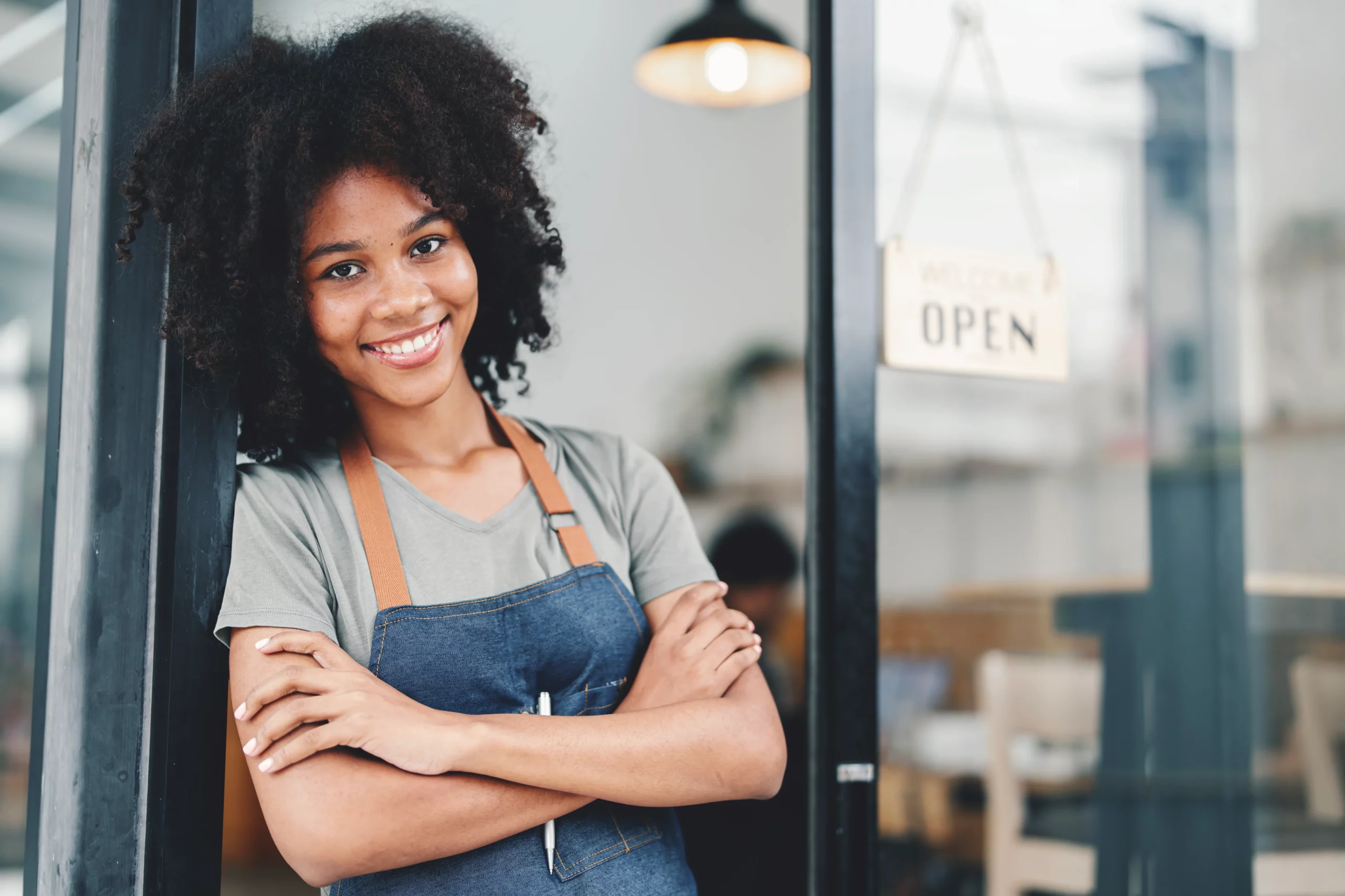 Smiling café owner at entrance illustrating Florida small business owners comparing LLC and S‑Corp structures.