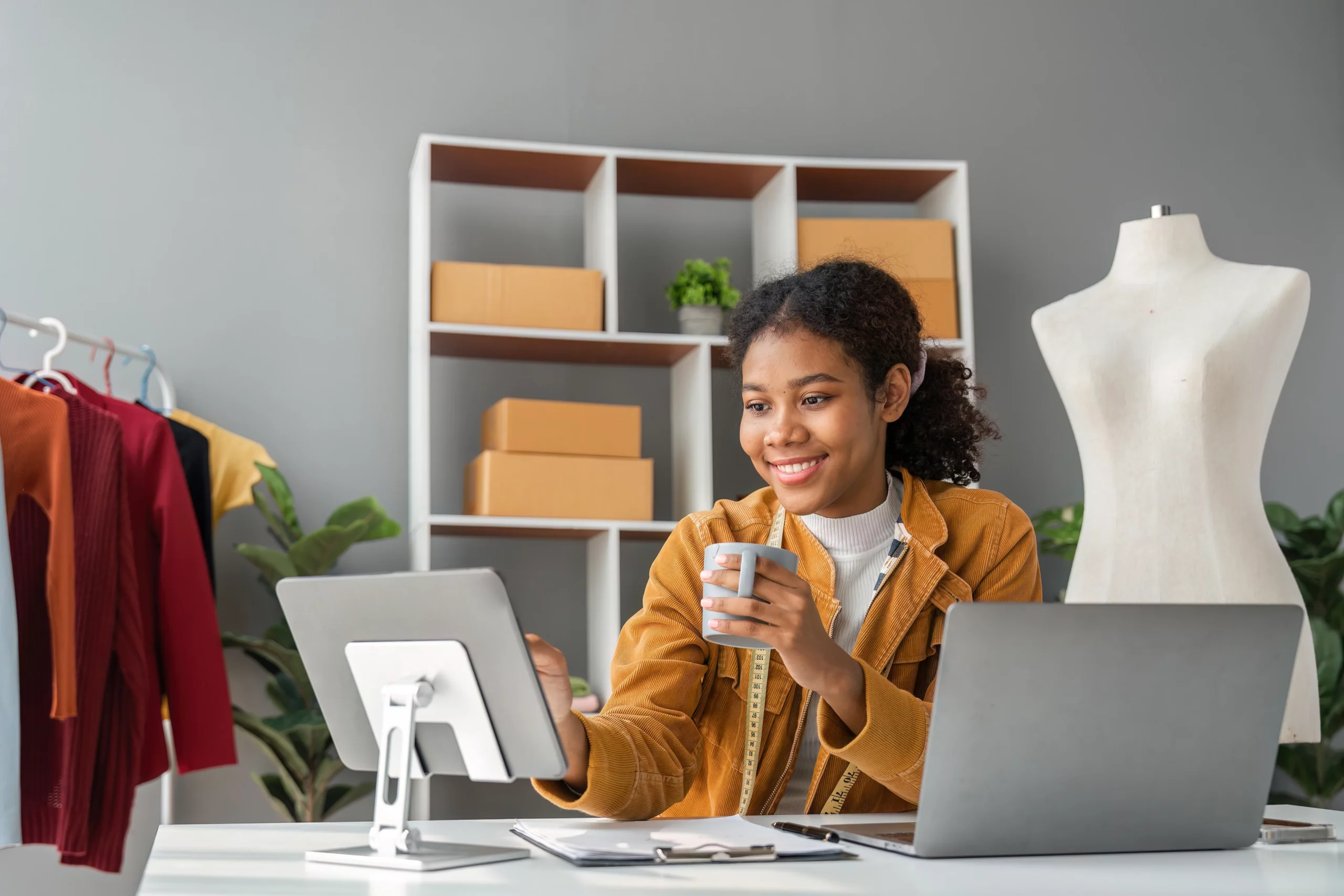 Smiling woman holding a mug and using tablet in creative office, illustrating Florida online business and licensing questions.