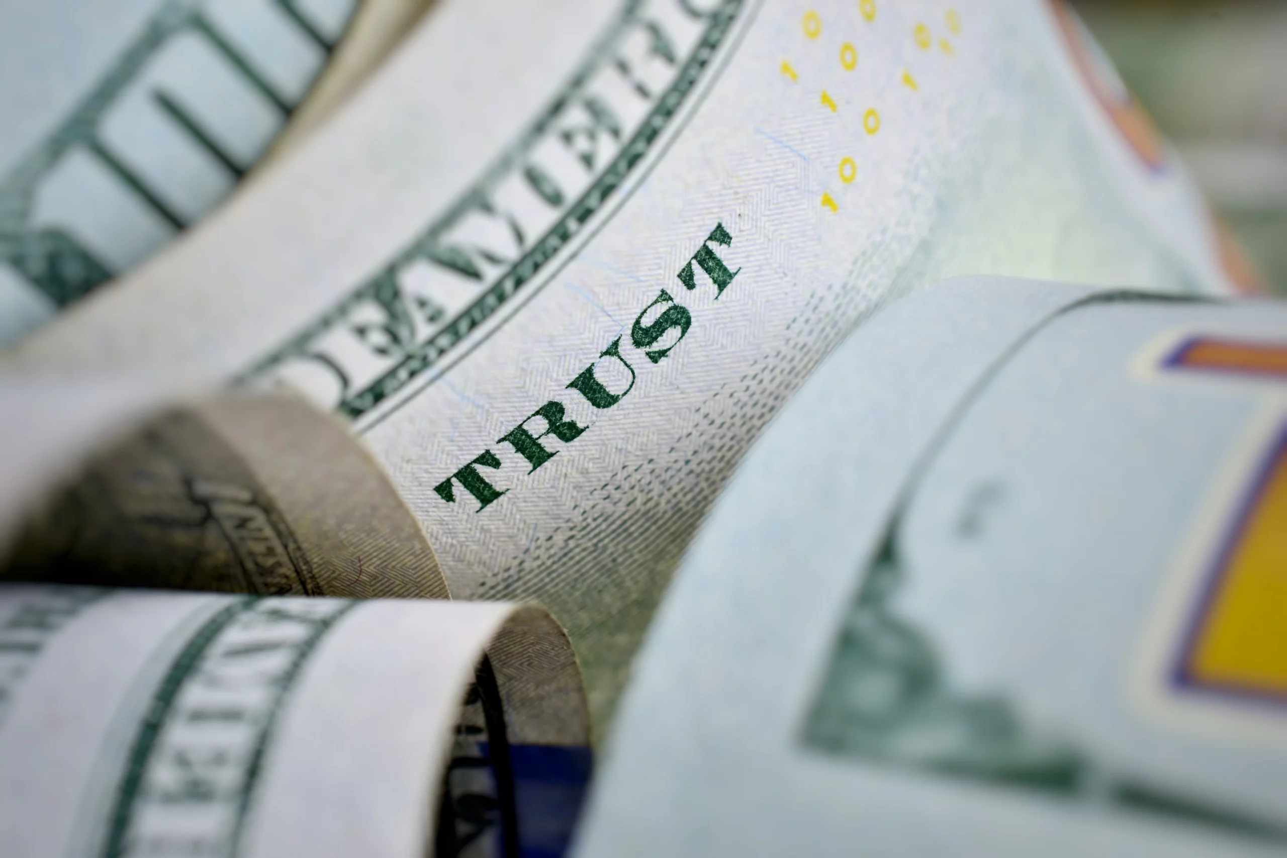 Rolled U.S. dollar bills symbolizing financial trust planning and funding a revocable living trust