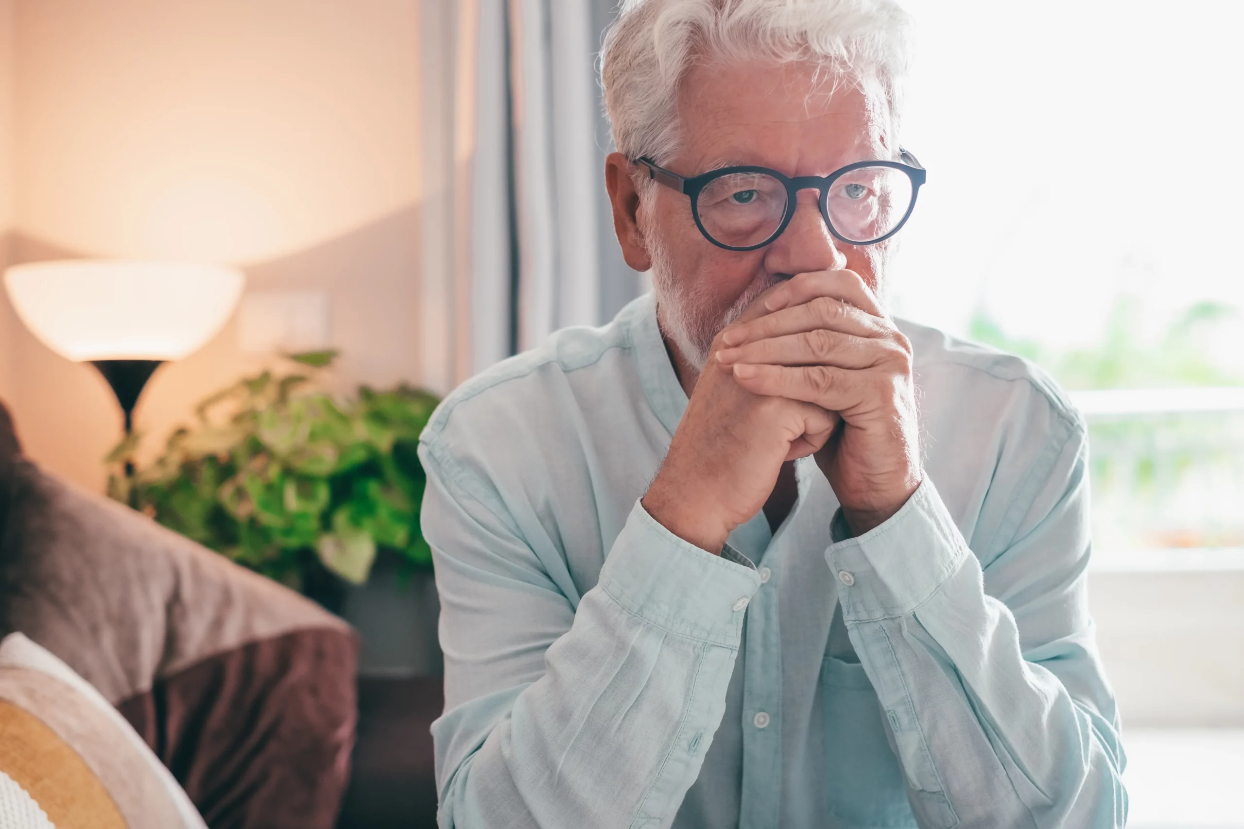 Elderly man sitting thoughtfully at home while considering estate planning and dying without a will in Florida