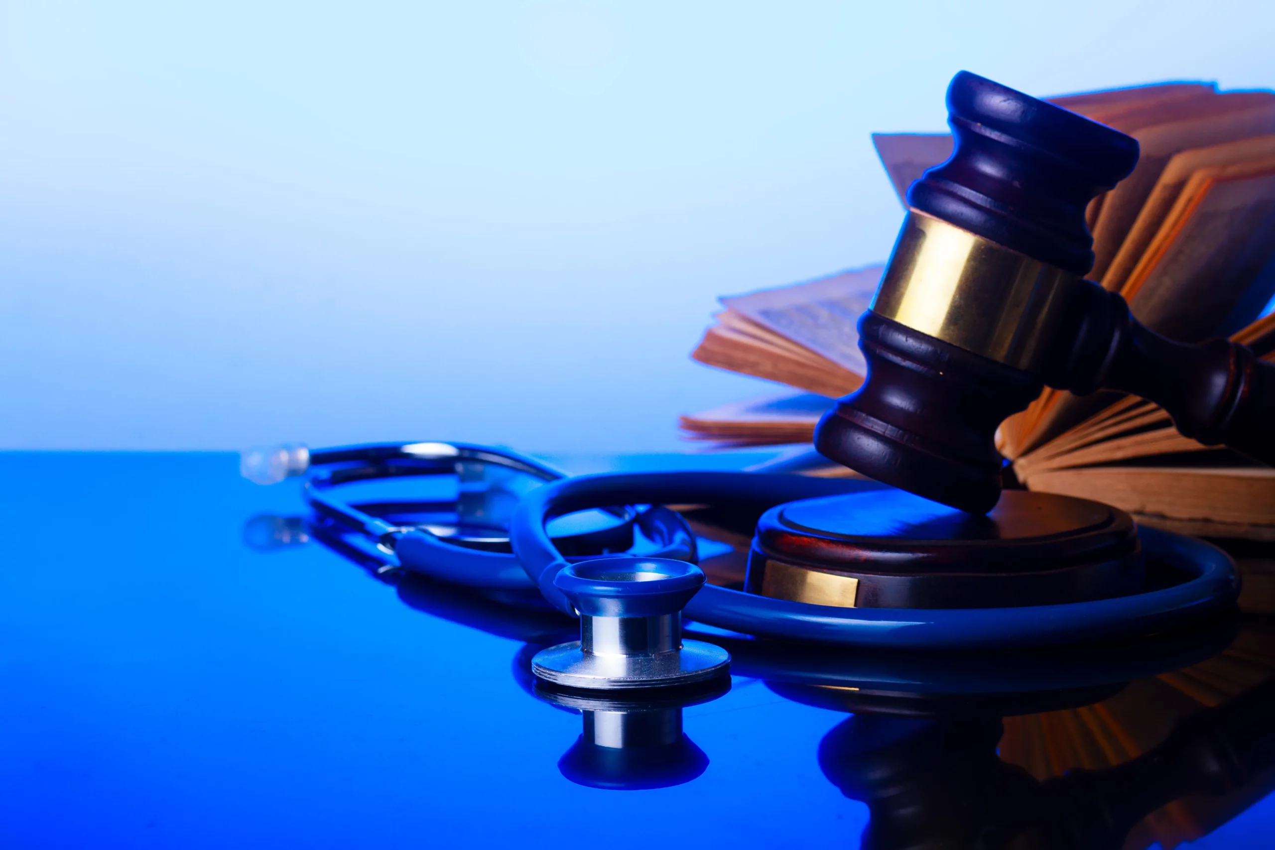 Wooden judge’s gavel resting on a stethoscope beside an open book, representing Florida power of attorney, healthcare directives, and legal decision-making for medical care and estate planning.