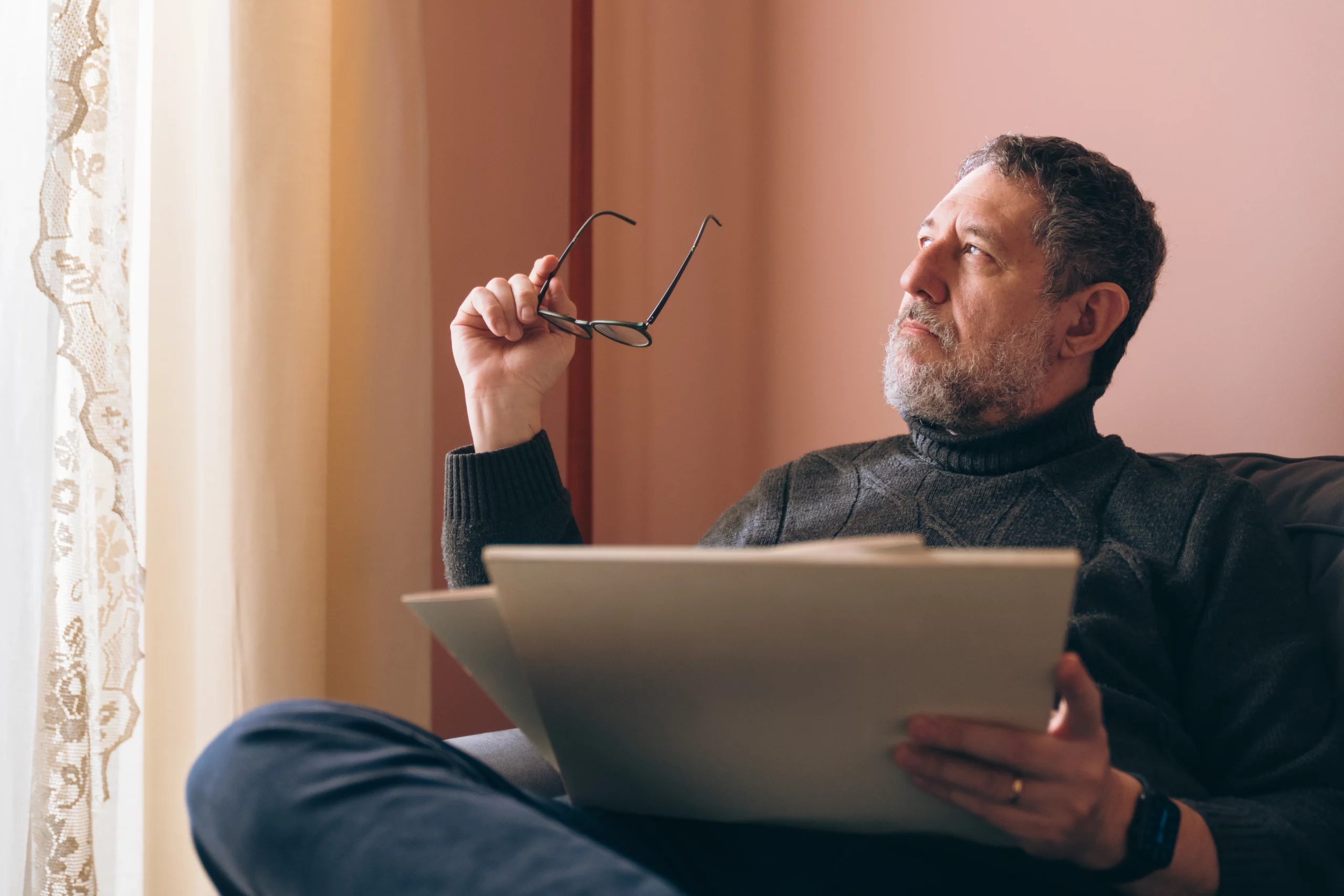 Thoughtful man reviewing estate planning documents while considering whether a will or trust is the right choice to protect assets and loved ones under Florida law.